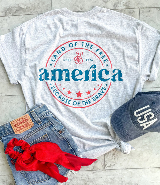 Camiseta supersuave con el símbolo de la paz en el bolsillo frontal del pecho y el logo retro americano en la espalda. La camiseta está preencogida y sus colores vibrantes no se destiñen.- talla 2XL